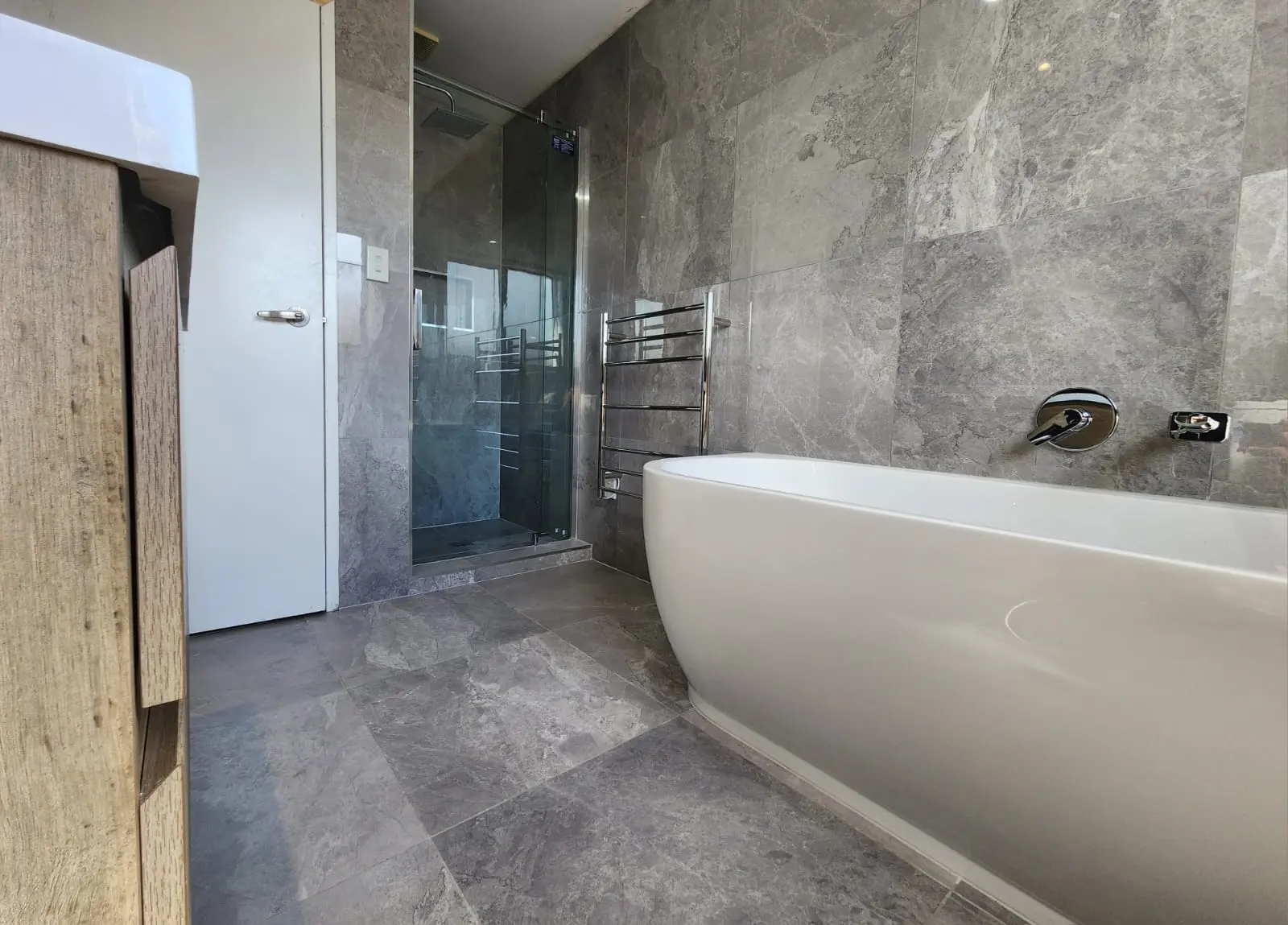 Modern bathroom renovation with white tiles and sleek fixtures